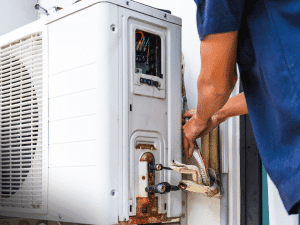 Technician inspecting outdoor HVAC unit and wiring during a home inspection in Jacksonville, FL